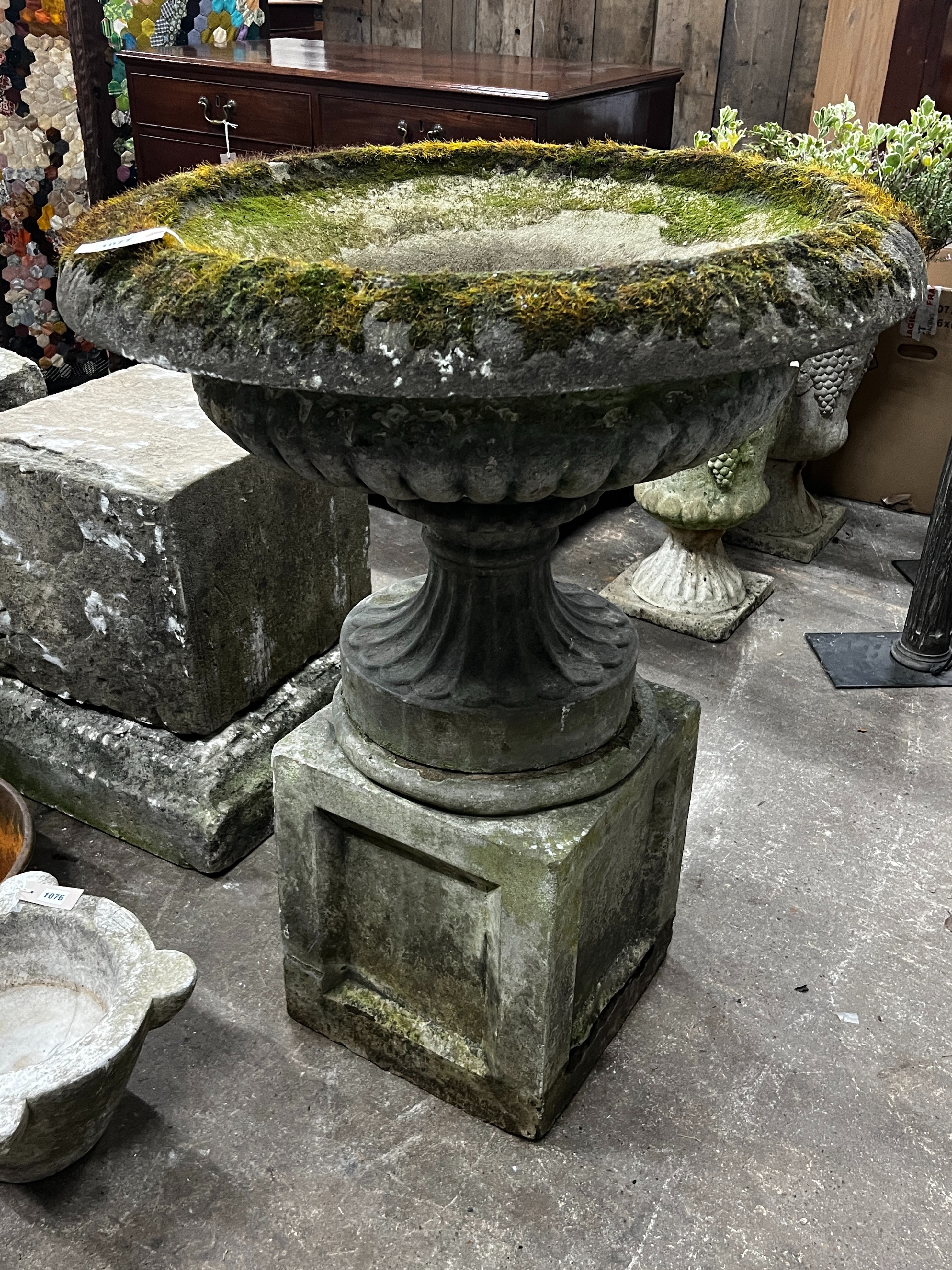 A reconstituted stone circular campana planter on square plinth, diameter 80cm, height 102cm